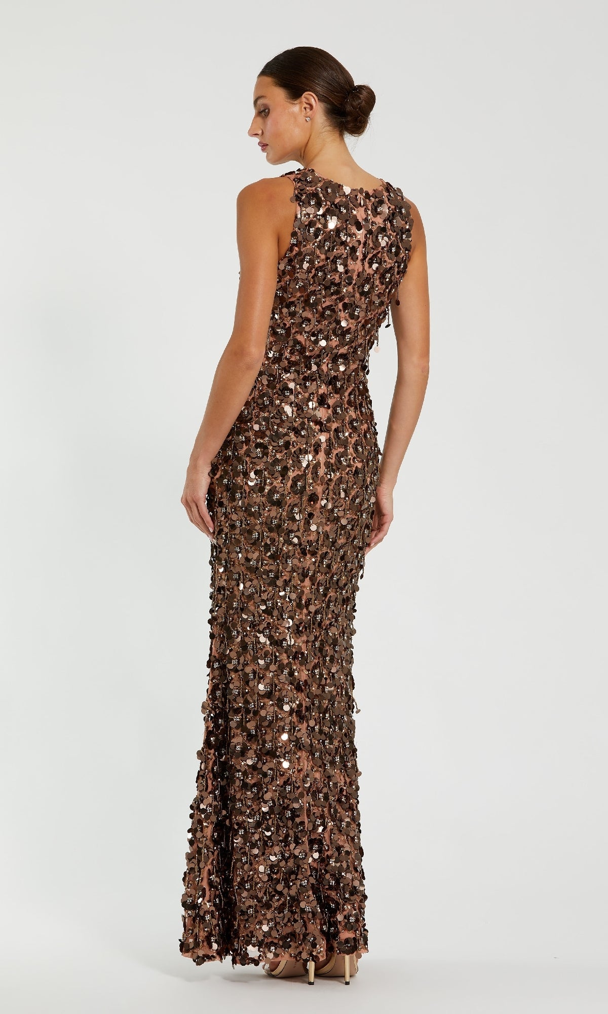Woman wearing a bronze sequin dress on a white background